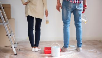 Man and woman painting house.